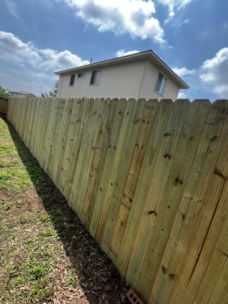Newly completed wood privacy fence installation in a Hutto, TX residential backyard