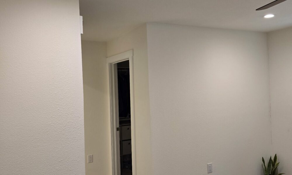 Contractor performing detailed interior painting services on a living room wall in Hutto